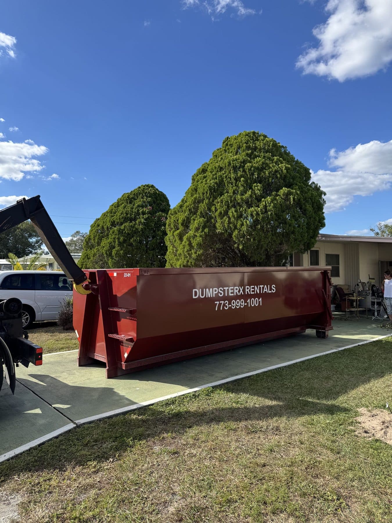 DumpsterX roll-off truck delivering a 22 yard dumpster to a job site